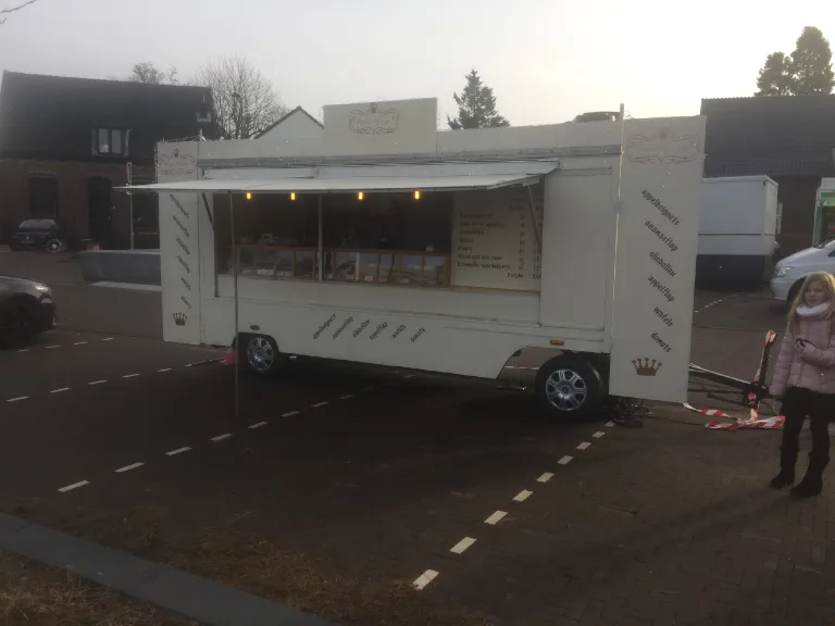 Witte verkoopwagen met luifel op locatie